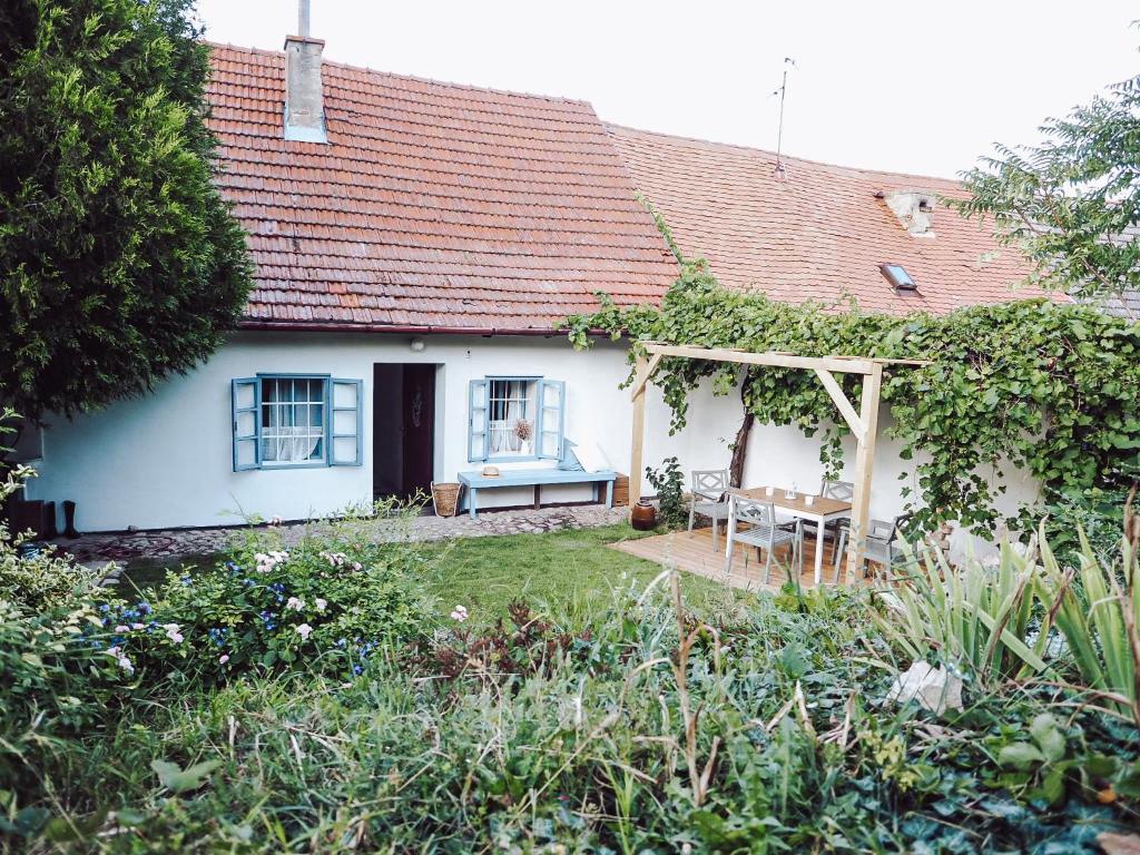 a white house with a bench and a table at Chaloupka Pálava in Pavlov