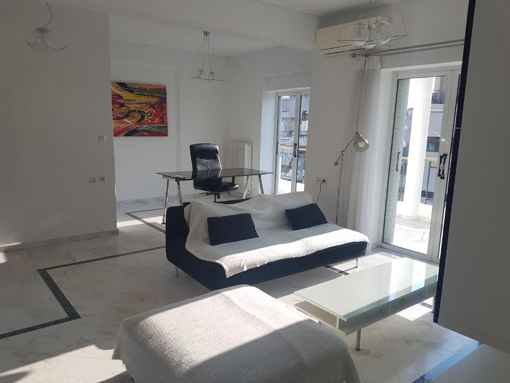 a bedroom with a bed and a table and a chair at NN Larisa Deluxe Apartment in Larisa