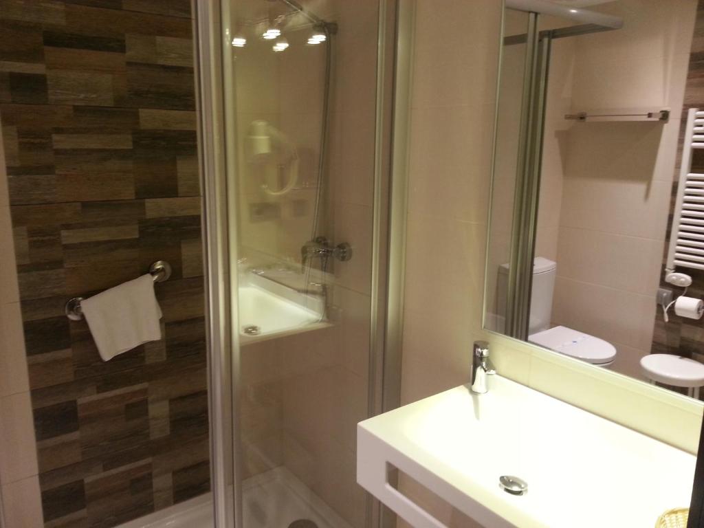 a bathroom with a shower and a sink and a mirror at Hotel Porto Calpe in Calpe