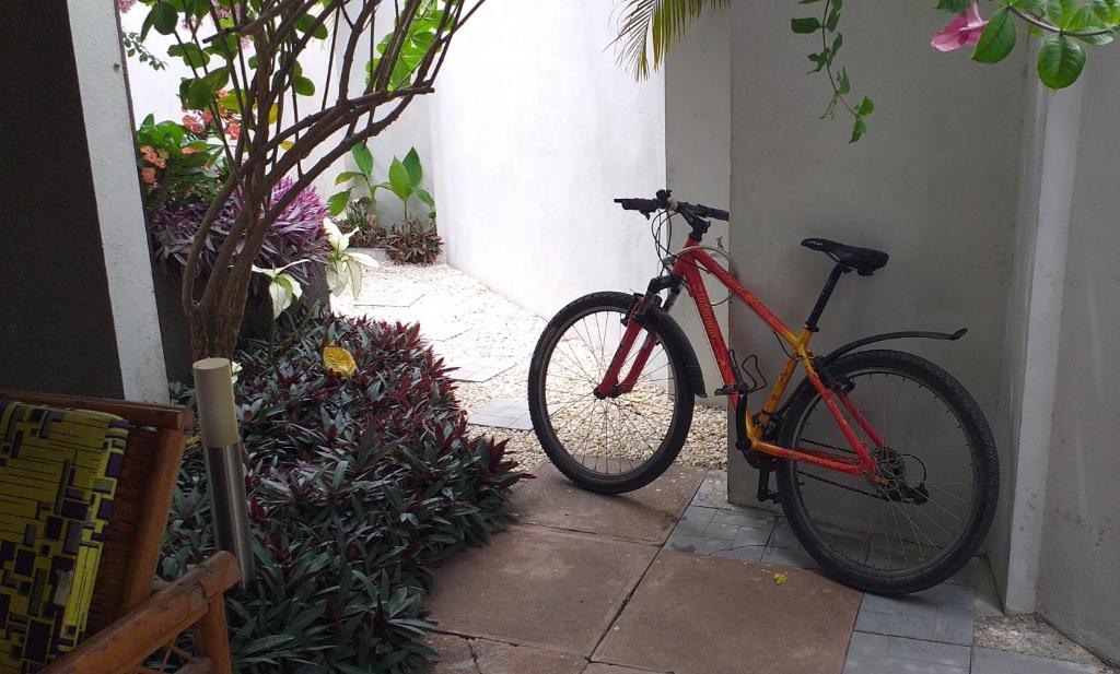 uma bicicleta vermelha estacionada ao lado de uma parede em KARLS guesthouse em Cotonou