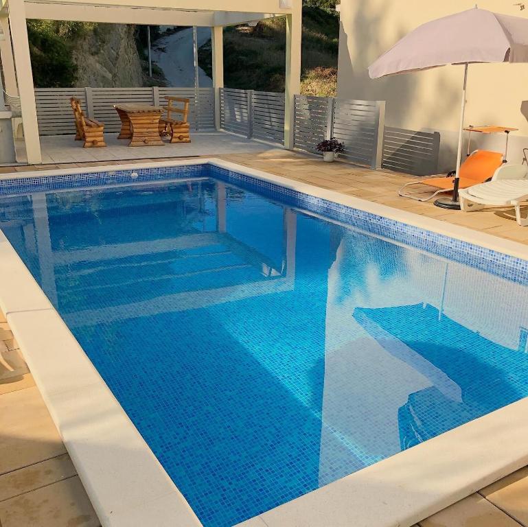 ein großer blauer Pool mit Sonnenschirm in der Unterkunft Vacation Rentals Croatia in Split