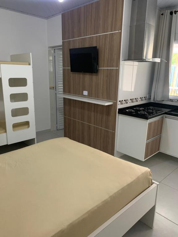 eine kleine Küche mit einem Bett in einem Zimmer in der Unterkunft Kitnet in Ubatuba