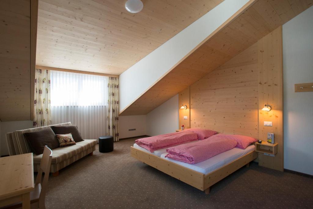 ein Schlafzimmer mit einem Bett und einem Sofa in einem Zimmer in der Unterkunft Waldgasthaus Lehmen in Weissbad