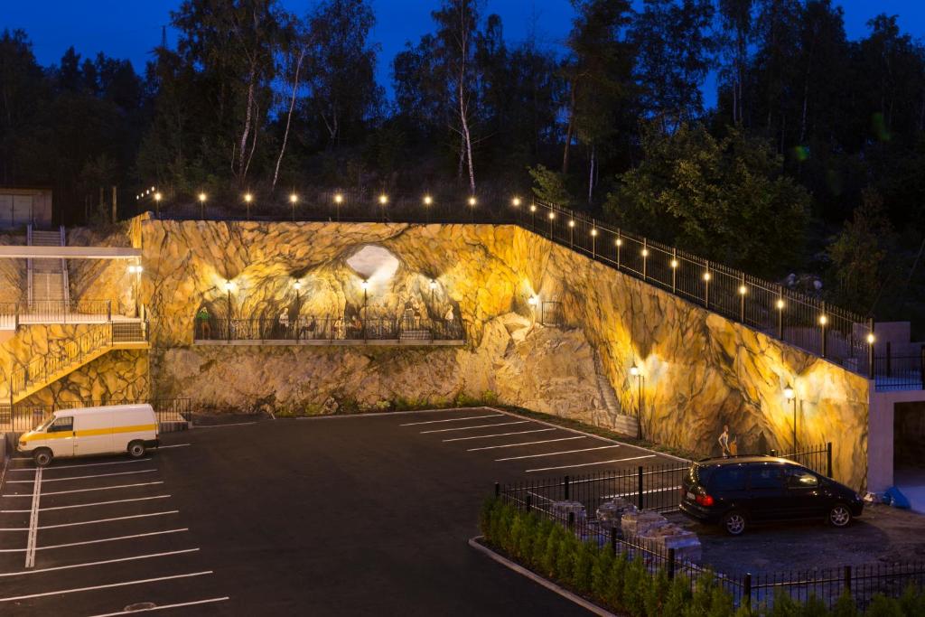 a parking lot with a car parked next to a stone wall at Hotel Dvorana in Karlovy Vary