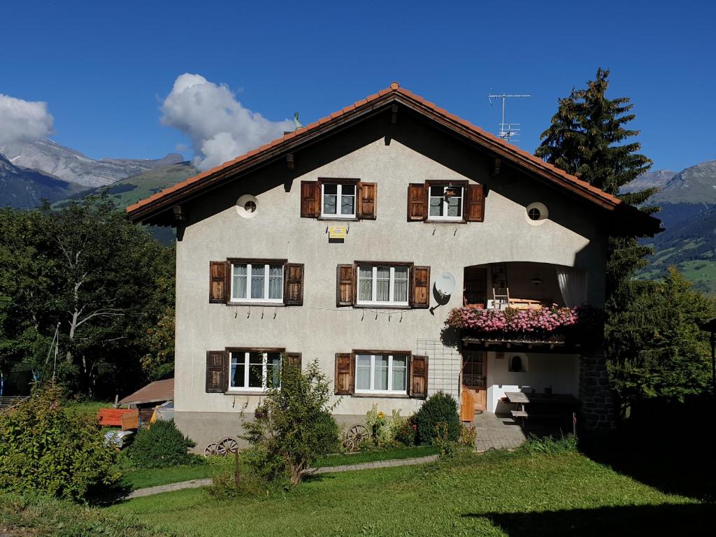 a house in the mountains with smoke coming at Ferienwohnung Antonia in Surcuolm