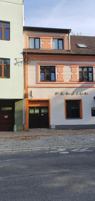 un grande edificio con due porte garage su una strada di Penzion U Kohoutka a Pardubice