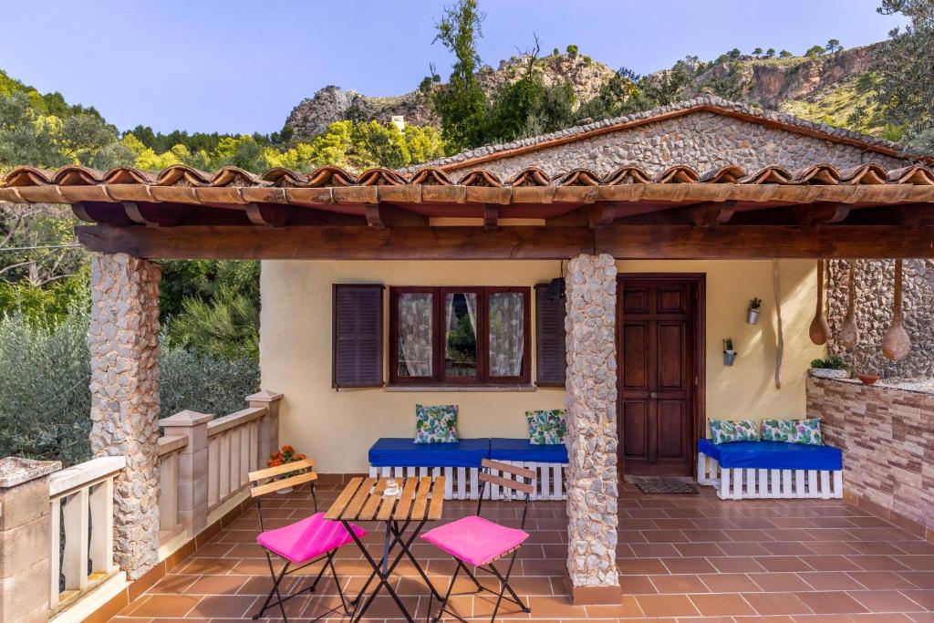 a patio with pink and blue chairs and a house at Can Sito in Cala Tuent