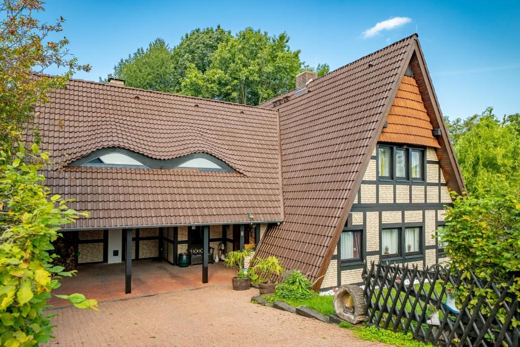 ein großes Haus mit braunem Dach in der Unterkunft Apartment am Bullerbach Deister in Barsinghausen