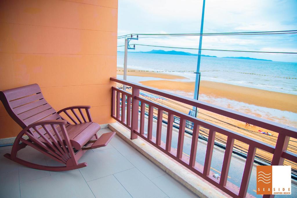 a rocking chair on a balcony with a view of the beach at Seaside Jomtien Beach Pattaya in Jomtien Beach