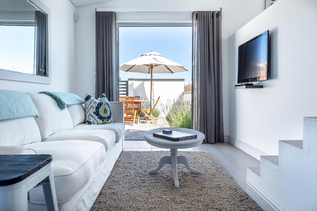 a living room with a white couch and a table at Pelicans View in Yzerfontein