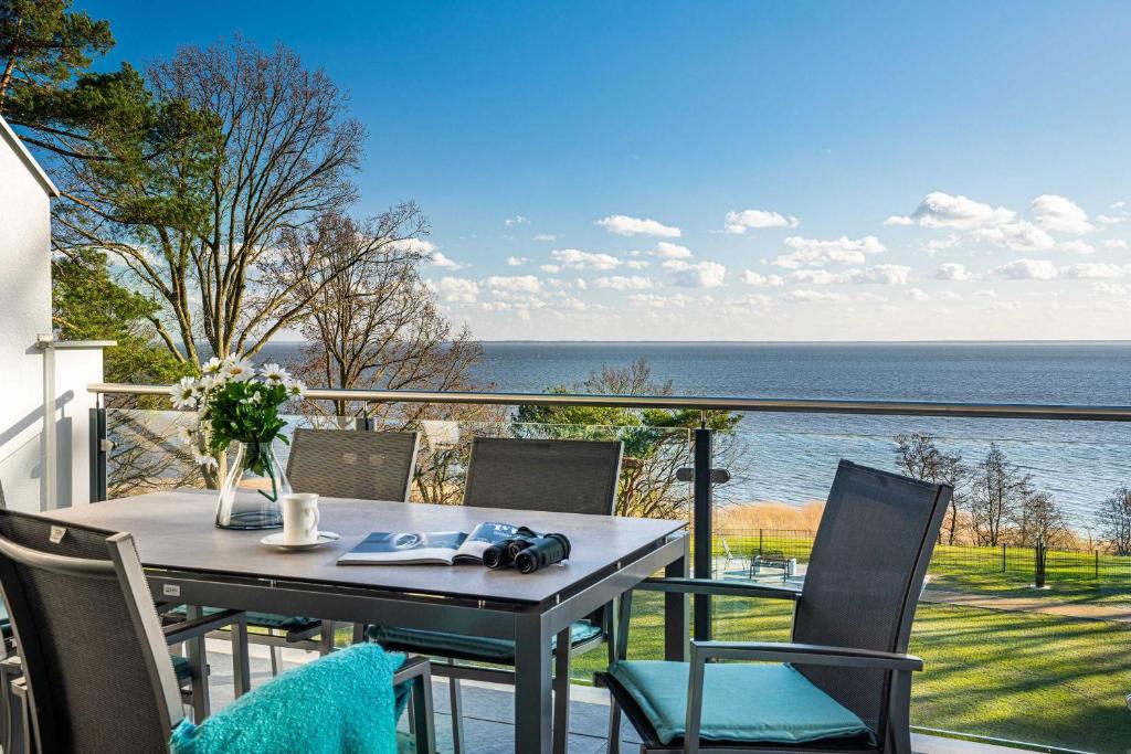 a table and chairs on a balcony with a view of the ocean at Appartement "Kliffkante" mit Penthouseflair - Oase am Haff in Garz-Usedom