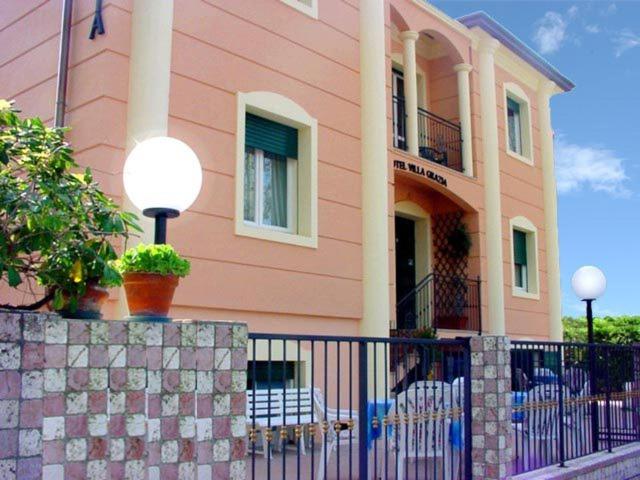 a pink house with chairs in front of it at Hotel Villa Grazia in Cesenatico