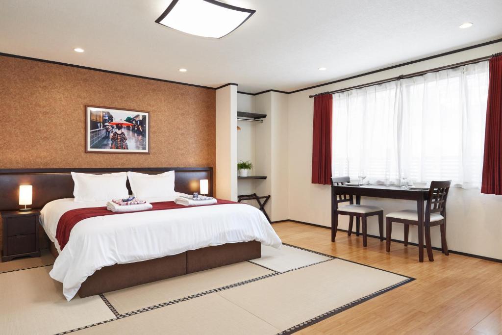 um quarto com uma cama, uma secretária e uma mesa em The Address Akakura em Myoko