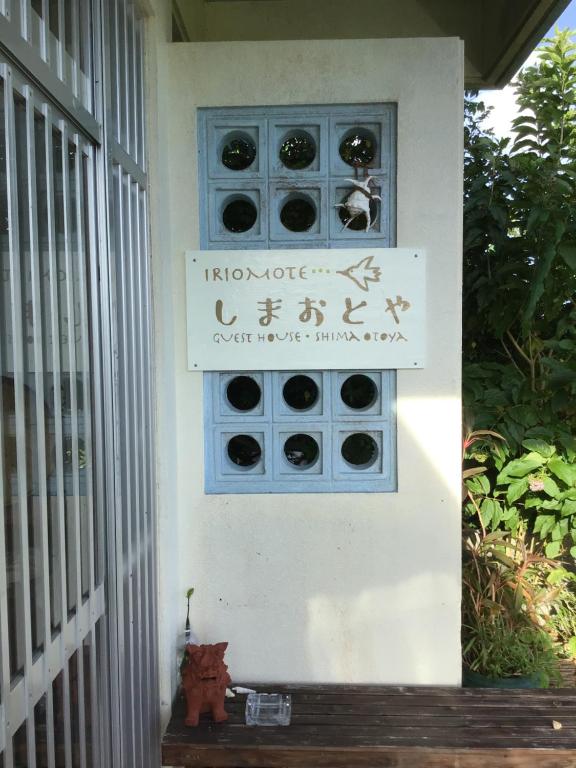 a sign on the side of a building with a sign on it at Shimaotoya in Iriomote