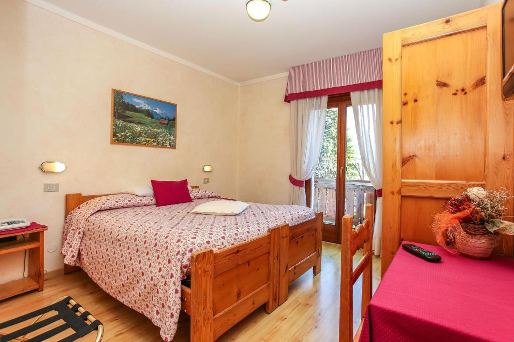 a bedroom with a bed and a window at Albergo Adele in Bormio