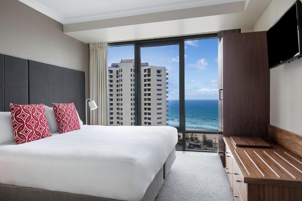 a bedroom with a large bed and a large window at Mantra Legends Hotel in Gold Coast