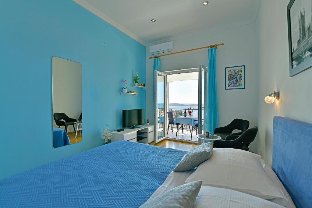 a blue bedroom with a bed and a view of the ocean at Apartments Tamara in Hvar