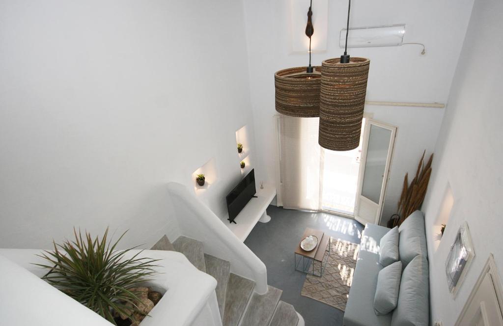 sala de estar con sofá blanco y lámpara de araña en 5 Traditional Suites en Livadi Astypalaias