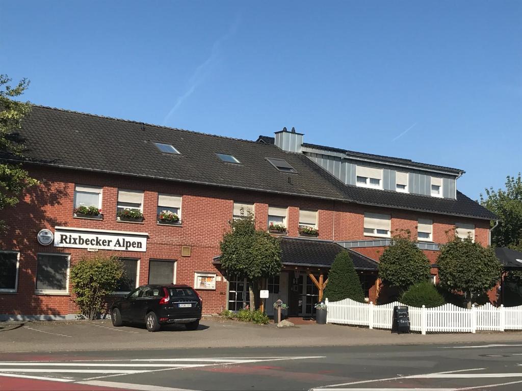 a building with a car parked in front of it at Rixbecker Alpen - Hotel Koch in Lippstadt