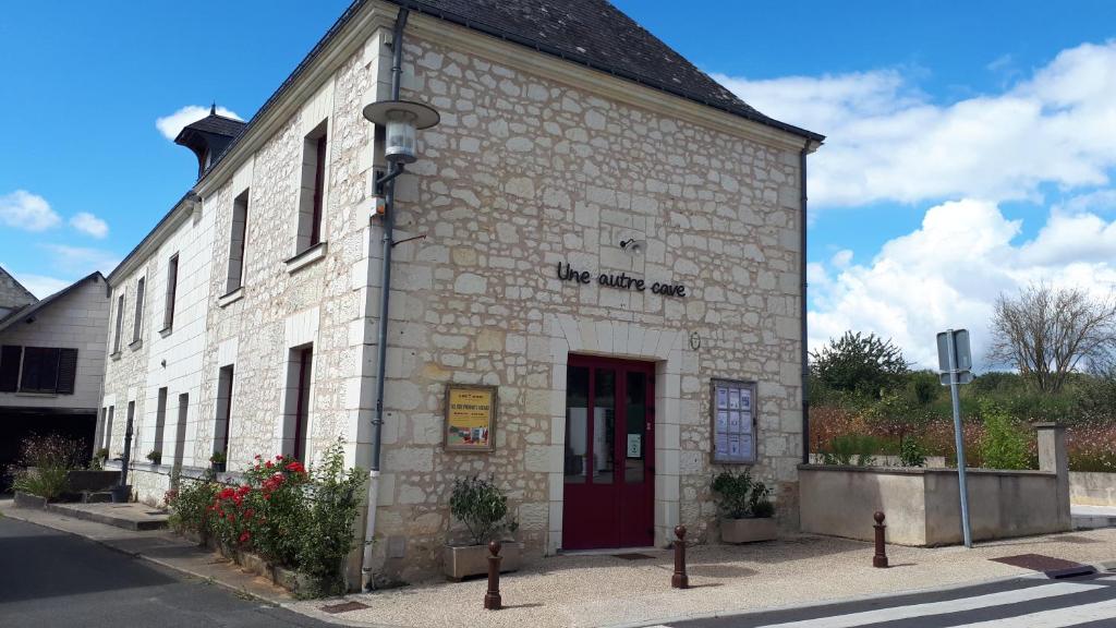 an old stone building with a red door on a street at Bulle de campagne à Saint Benoit la Forêt in Saint-Benoît-la-Forêt