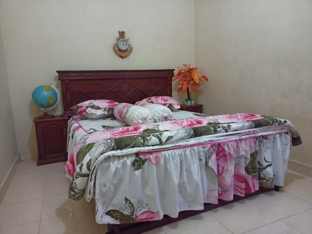 - une chambre dotée d'un lit avec des draps roses et blancs dans l'établissement FERMANA HOMESTAY, à Painan
