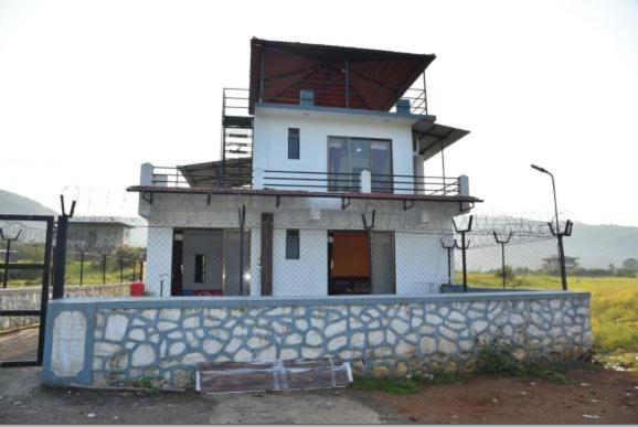 een klein wit huis met een hek ervoor bij Killer Villa 3 BHK in Lonavala