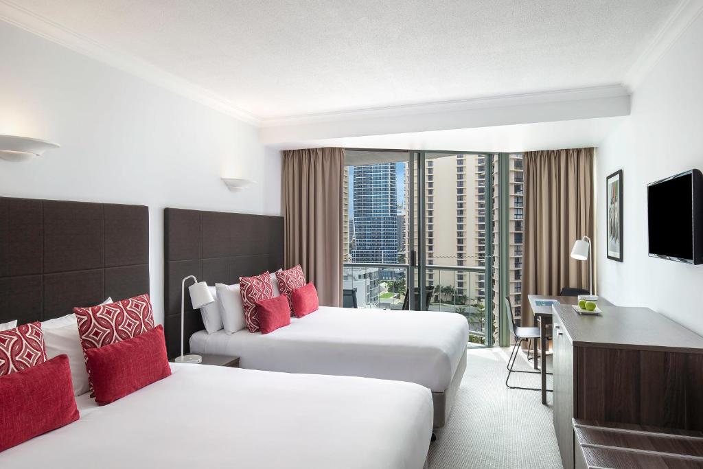 a hotel room with two beds with red pillows at Mantra Legends Hotel in Gold Coast