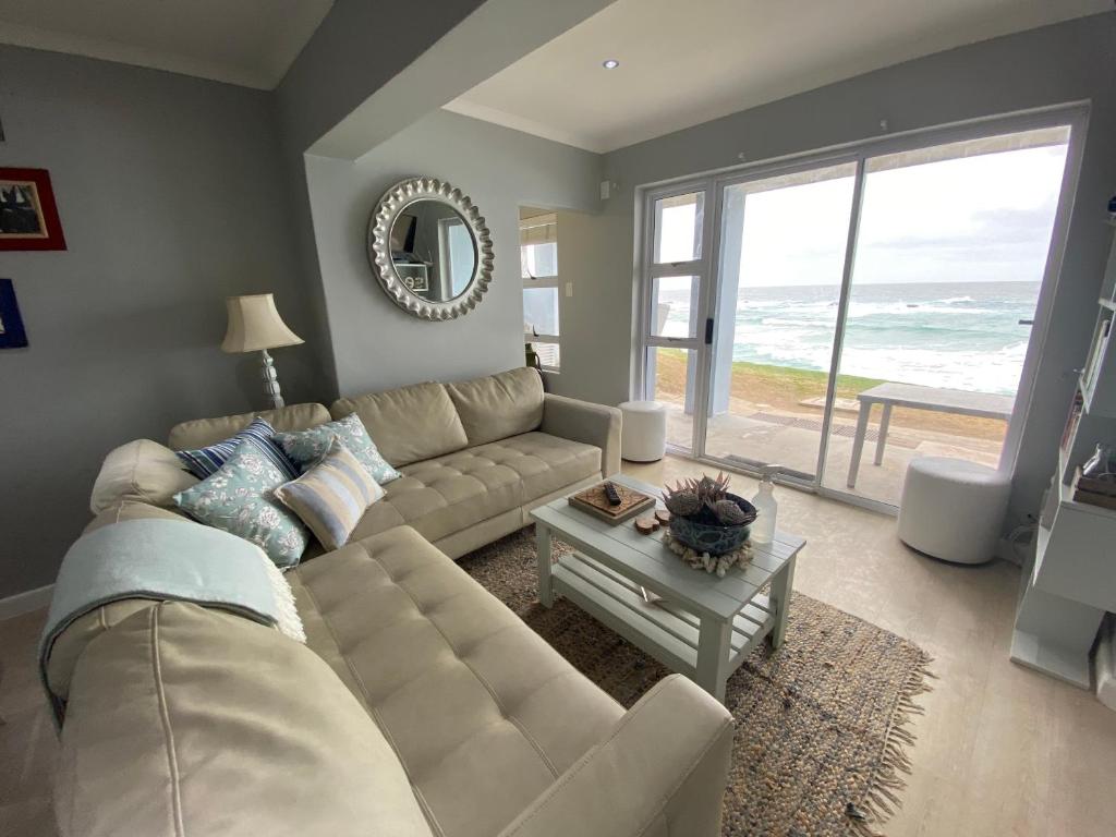 a living room with a couch and a view of the ocean at Net Hier in Eersterivierstrand