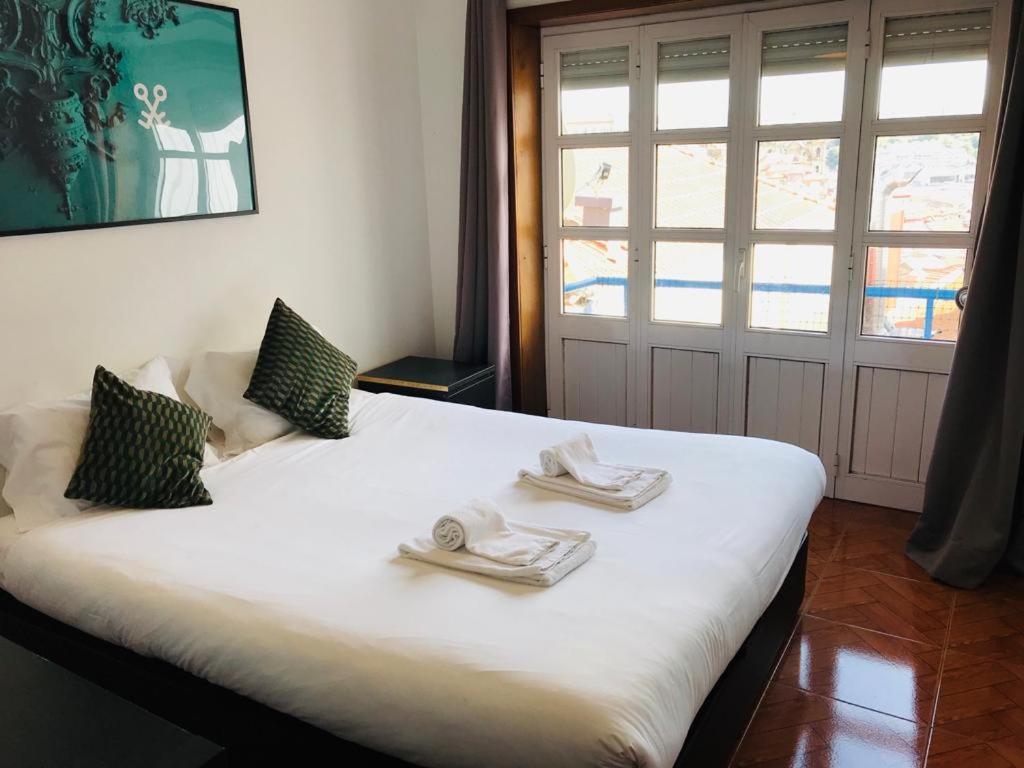 ポルトにあるClérigos Apartmentsのベッドルーム1室(白いベッド1台、タオル付)