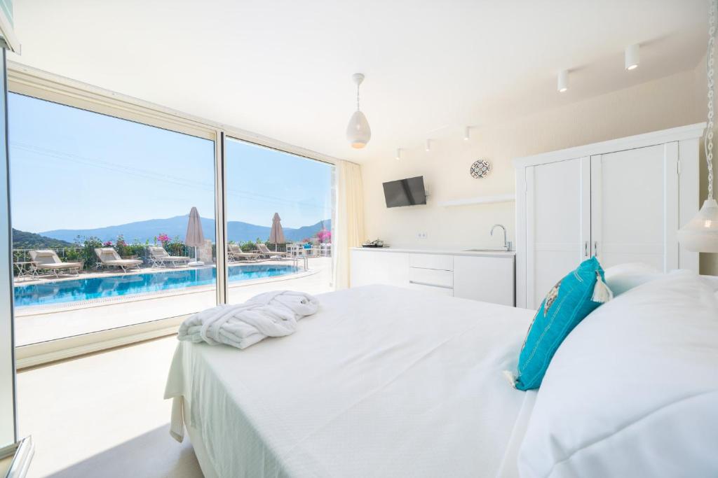 ein Schlafzimmer mit einem großen weißen Bett und einem großen Fenster in der Unterkunft Buqqva Residence in Kalkan