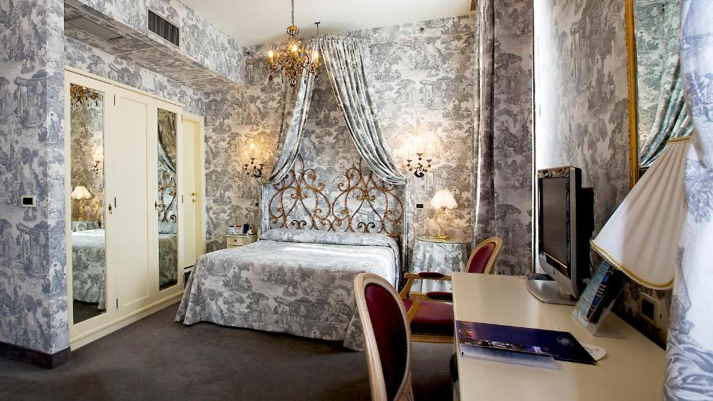 a bedroom with a bed and a desk and a tv at Hotel Principe in Venice