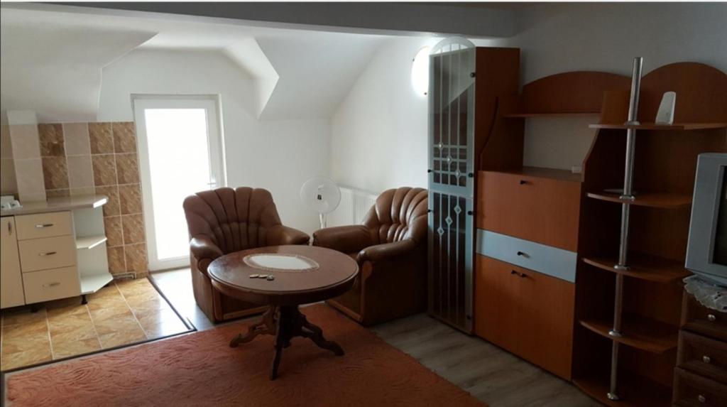 uma sala de estar com duas cadeiras, uma mesa e uma televisão em HABIBI em Paşcani