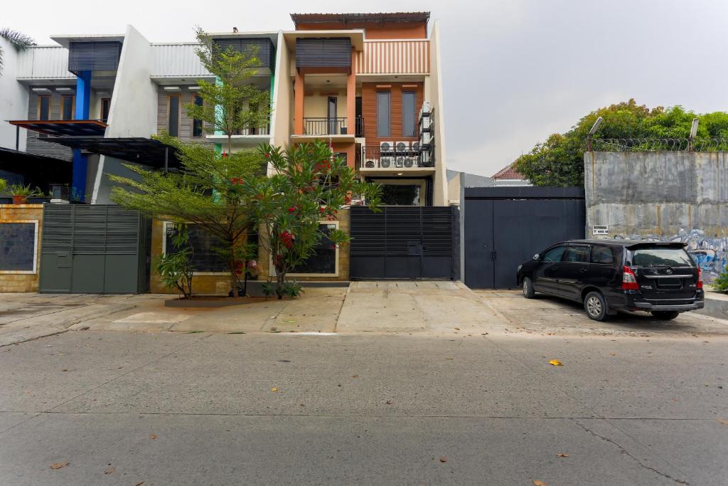 a car parked in a parking lot in front of a building at SUPER OYO 3109 Point Inn in Jakarta