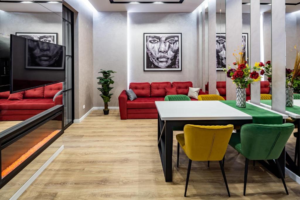 - un salon avec un canapé rouge, une table et des chaises dans l'établissement Alfa Apartments 3-кімнатна LUX-квартира у центрі Львова, à Lviv