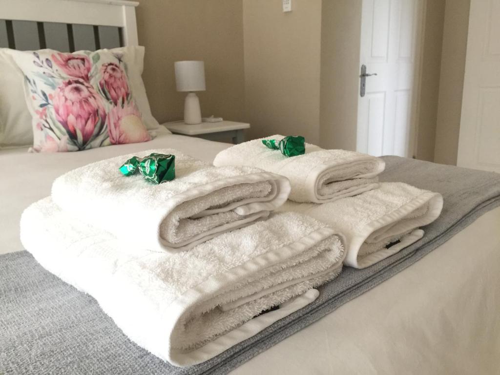 uma pilha de toalhas sentadas em cima de uma cama em The Vine em Klawer