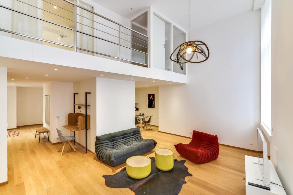 una sala de estar con muebles de color amarillo y rojo y una escalera. en High Standing Comfortable Loft 125m2 city center en Estrasburgo