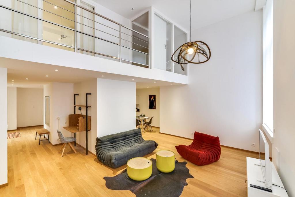 ストラスブールにあるHigh Standing Comfortable Loft 125m2 city centerのリビングルーム(黄色と赤の家具、階段付)