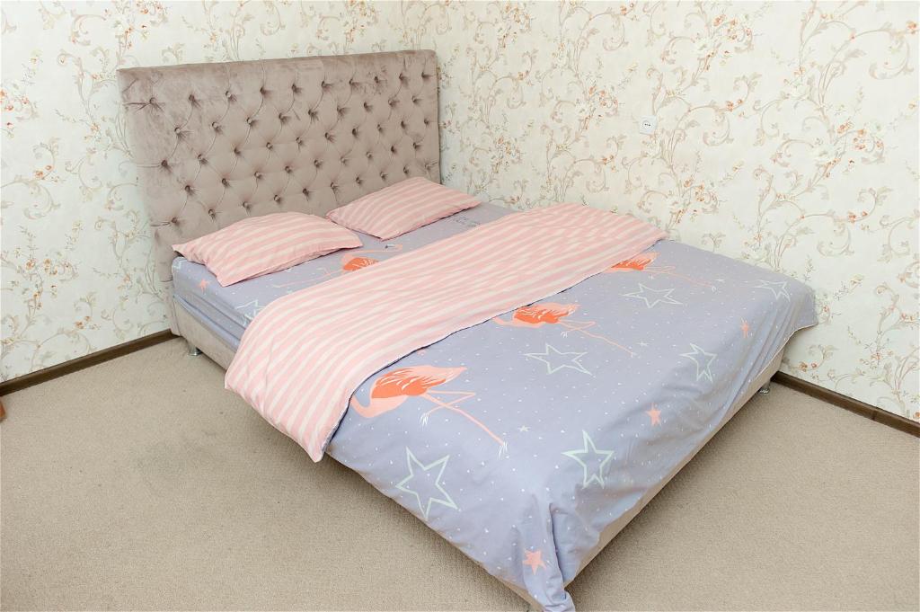 un letto con copriletto rosa e bianco con sopra gli uccelli di Охайна двокімнатна квартира біля Дніпра! a Čerkasy
