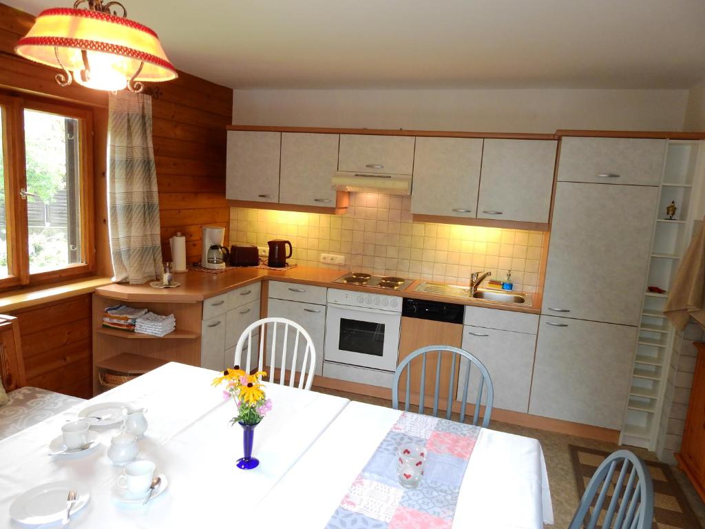 eine Küche mit einem Tisch und einer Blumenvase darauf in der Unterkunft Haus Berauer in Fieberbrunn