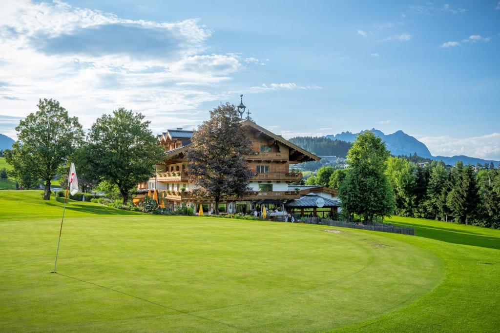 a golf course in front of a large building at Rasmushof - Hotel Kitzbühel in Kitzbühel