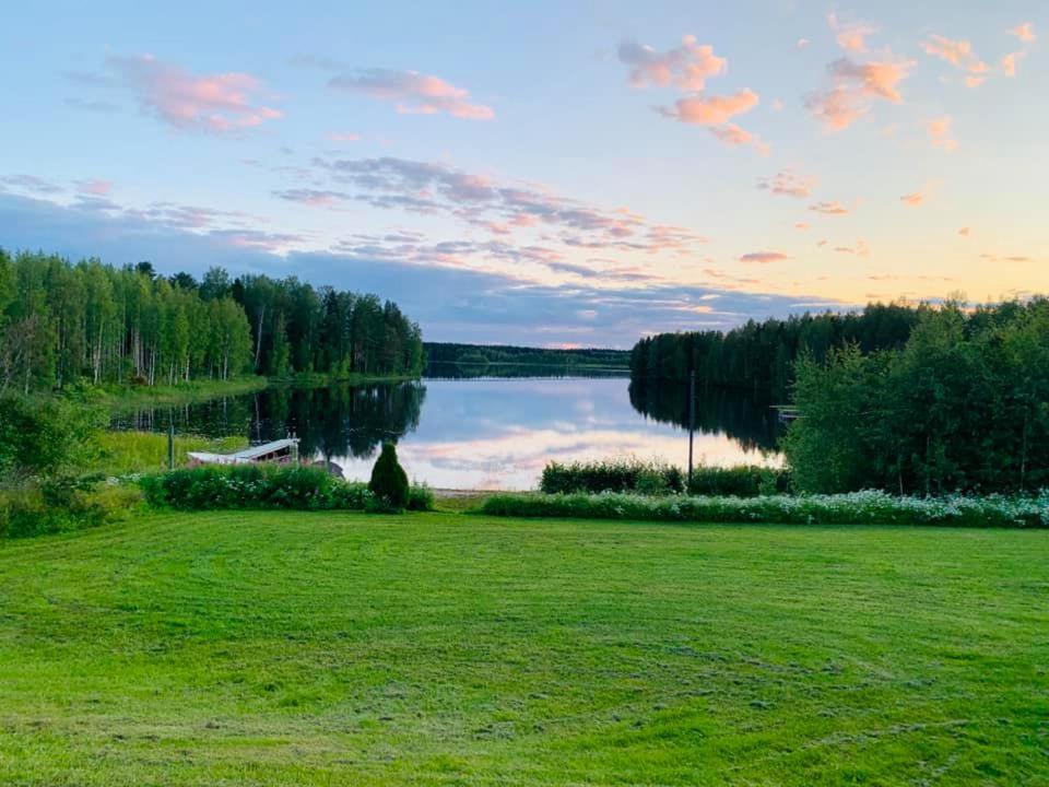 un prato con un lago sullo sfondo di Cottage Elsa a Kuopio