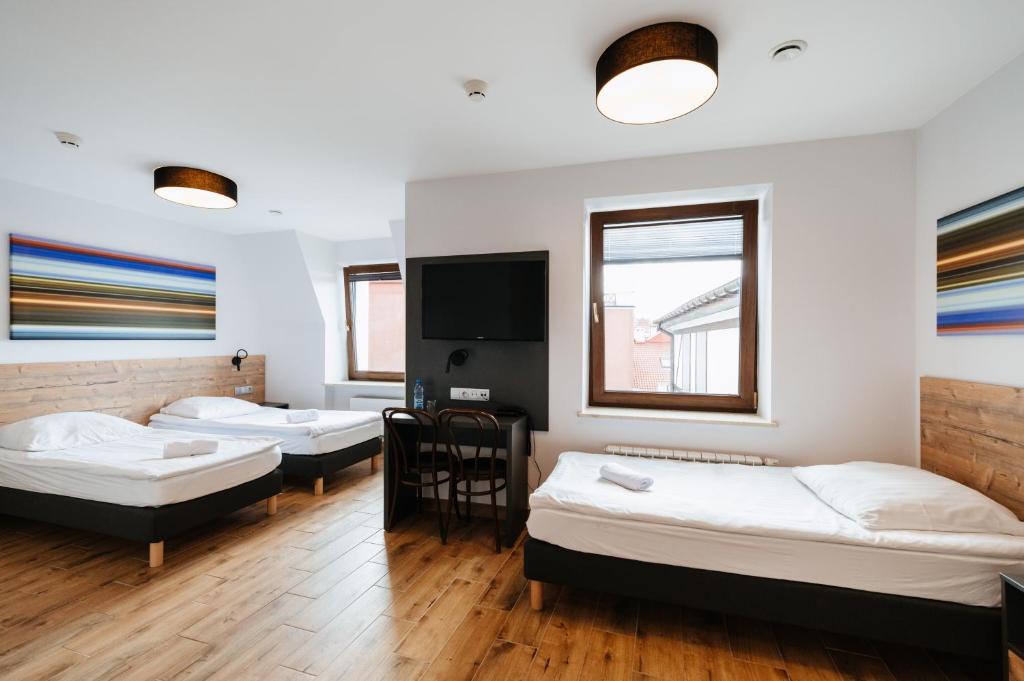 Pokój z 3 łóżkami i telewizorem z płaskim ekranem w obiekcie Horeka Hotel & SPA w mieście Ełk