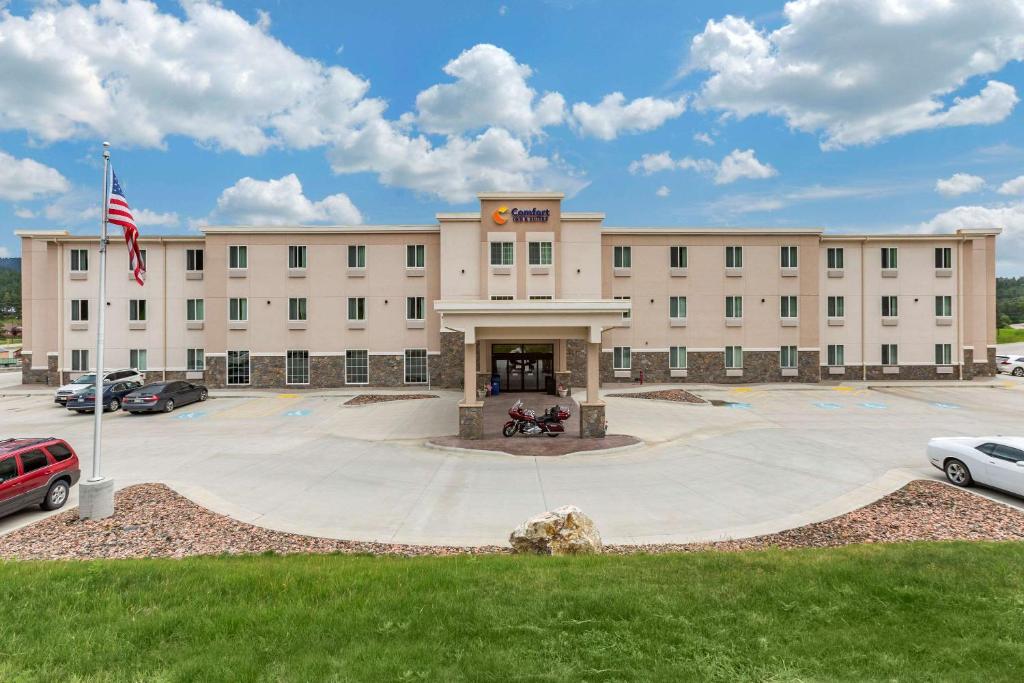 un gran edificio con una bandera delante de él en Comfort Inn & Suites Near Mt Rushmore en Hill City