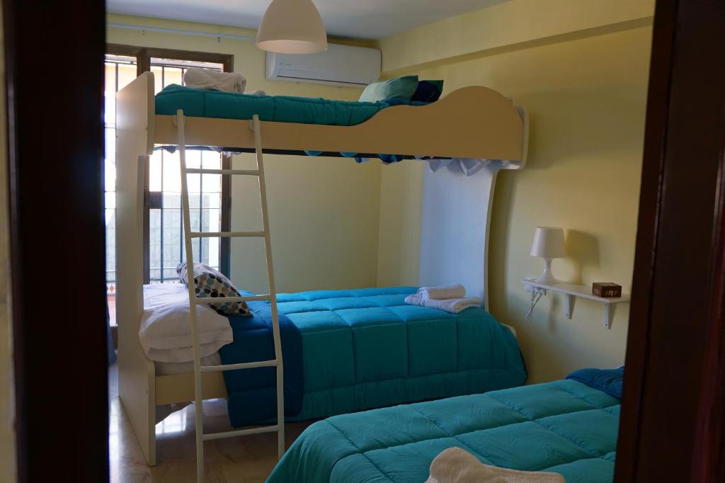 1 Schlafzimmer mit 2 Etagenbetten und einer Leiter in der Unterkunft Apartamento Centro Pergo in Córdoba