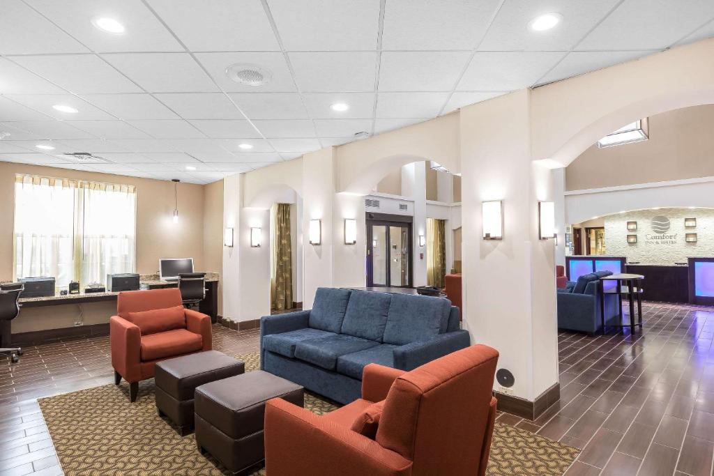 a waiting room with couches and chairs in a hospital at Comfort Inn & Suites Allen Park - Dearborn in Allen Park