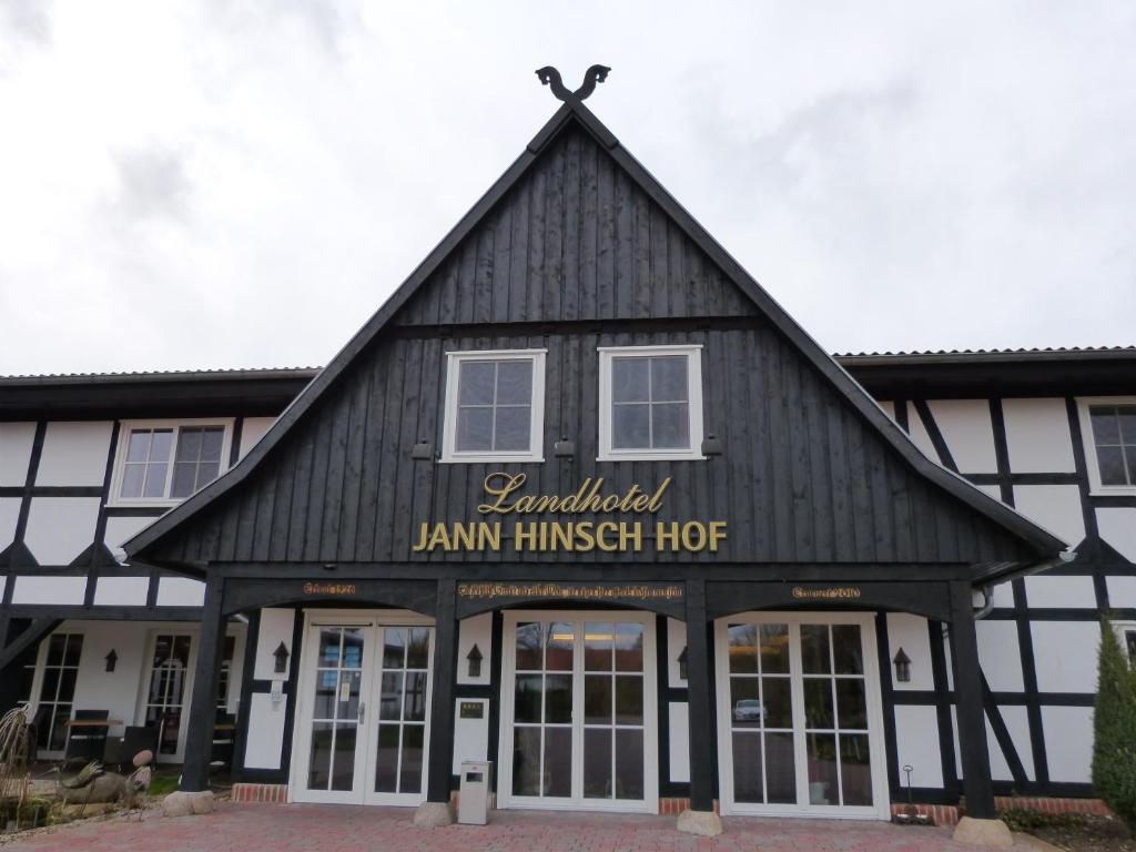 a black and white building with a sign on it at Landhotel Jann Hinsch Hof in Winsen Aller
