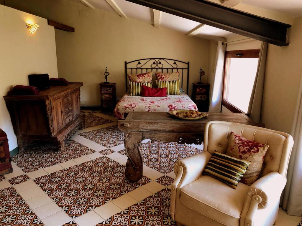 ein Schlafzimmer mit einem Bett, einem Tisch und einem Stuhl in der Unterkunft Cal Tató in Os de Balaguer