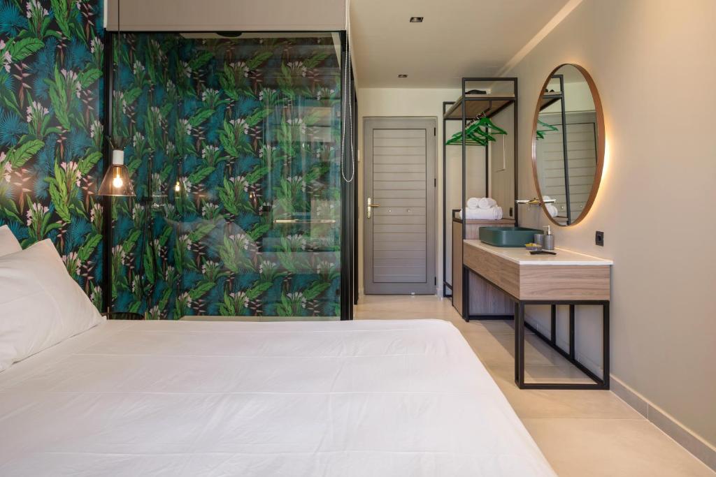 a bedroom with a bed and a sink and a mirror at Agave Boutique Hotel in Laganas