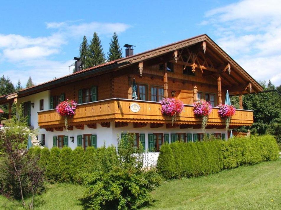 ein großes Holzhaus mit Blumen davor in der Unterkunft Landhaus Stephanie in Krün