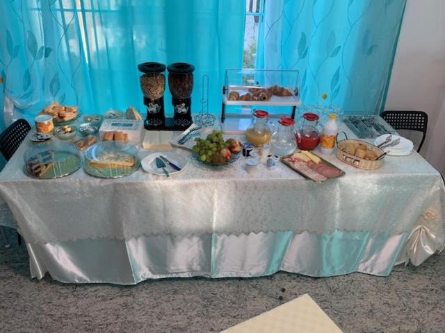 uma mesa branca com comida em cima em B & B Villa Fiorella em Termoli